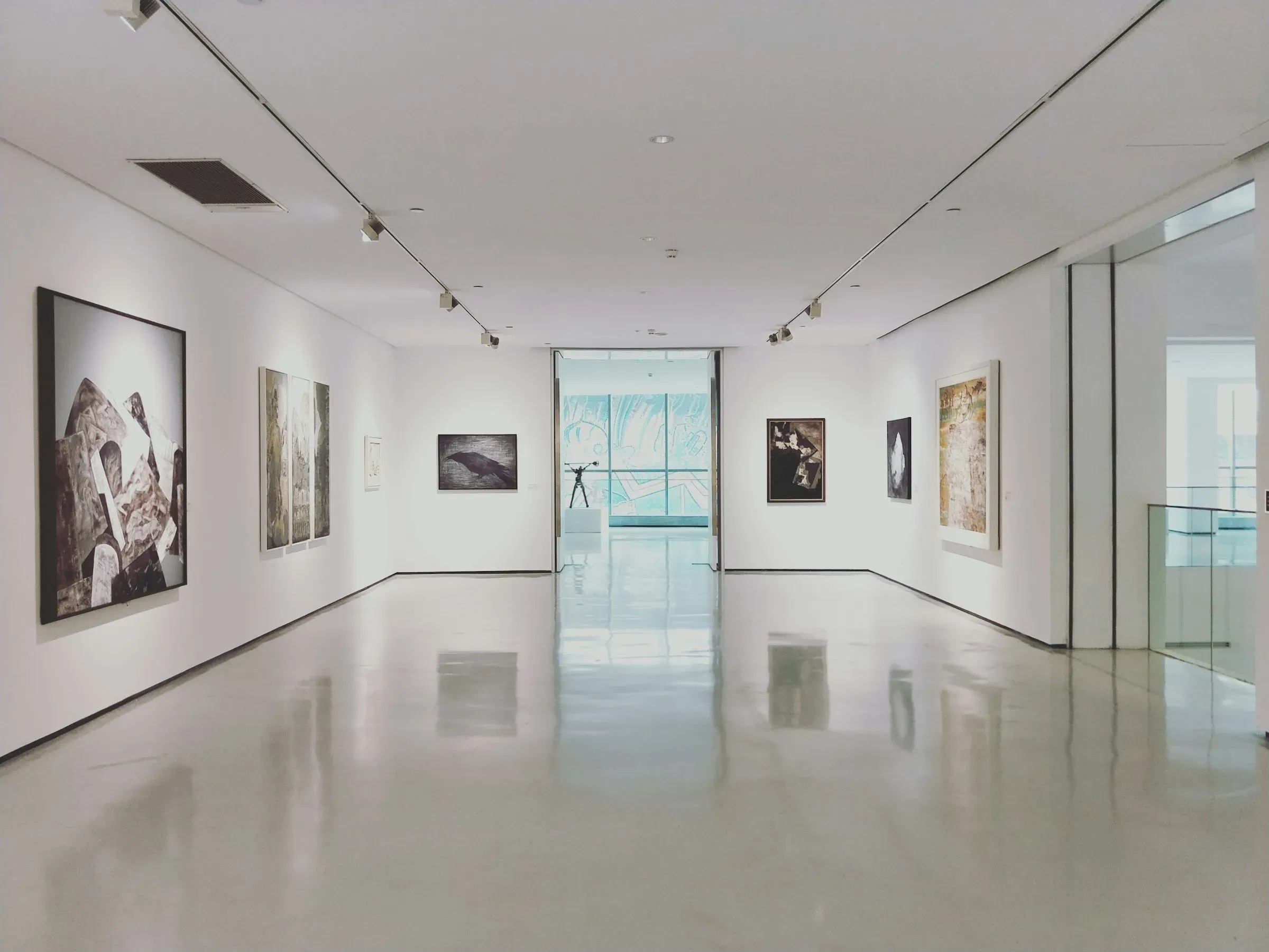A bright white gallery with photographs hung along both walls