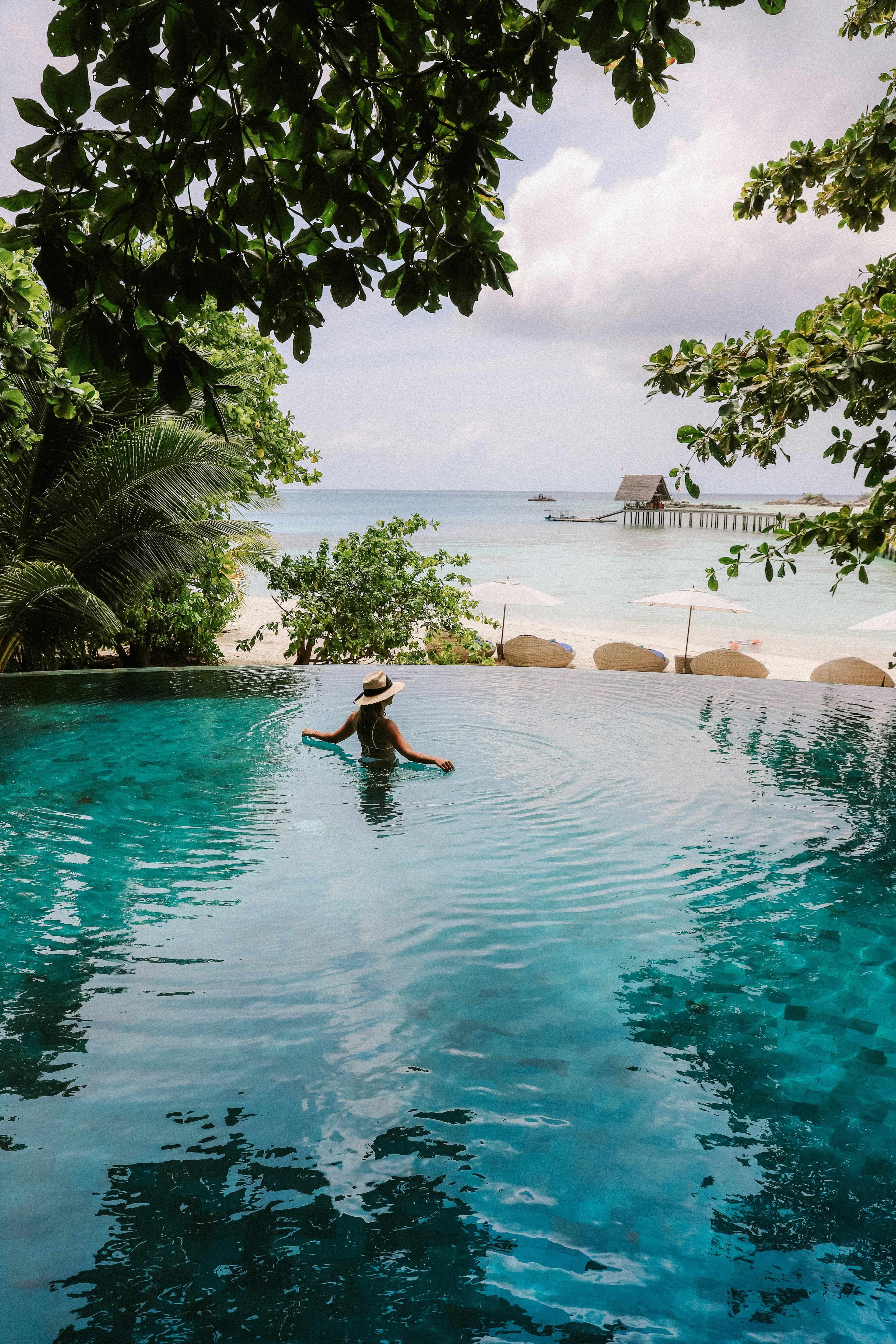 Infinity pool at dusk overlooking a tropical coastline