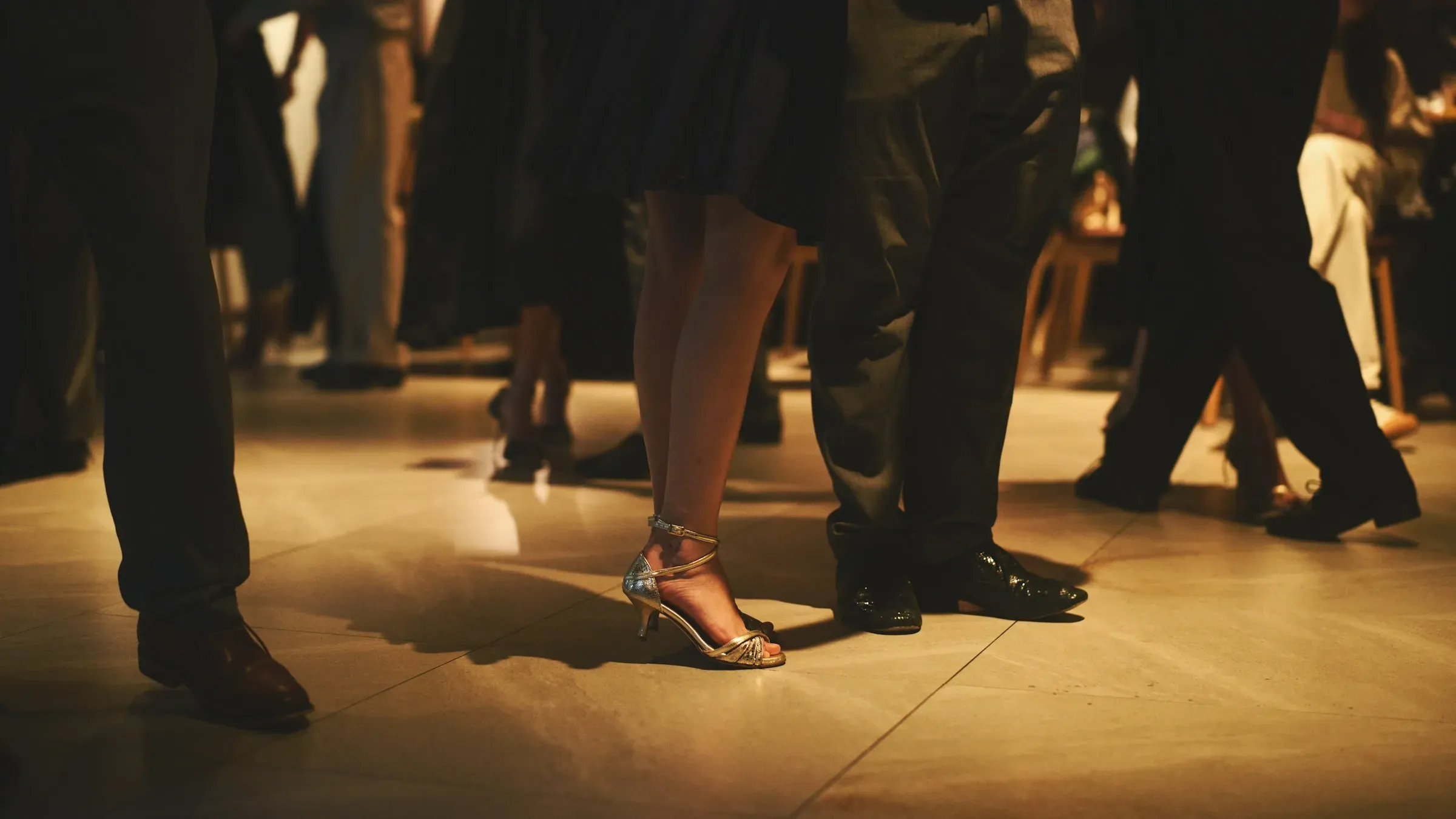 Guests in evening dress dancing, seen at floor level