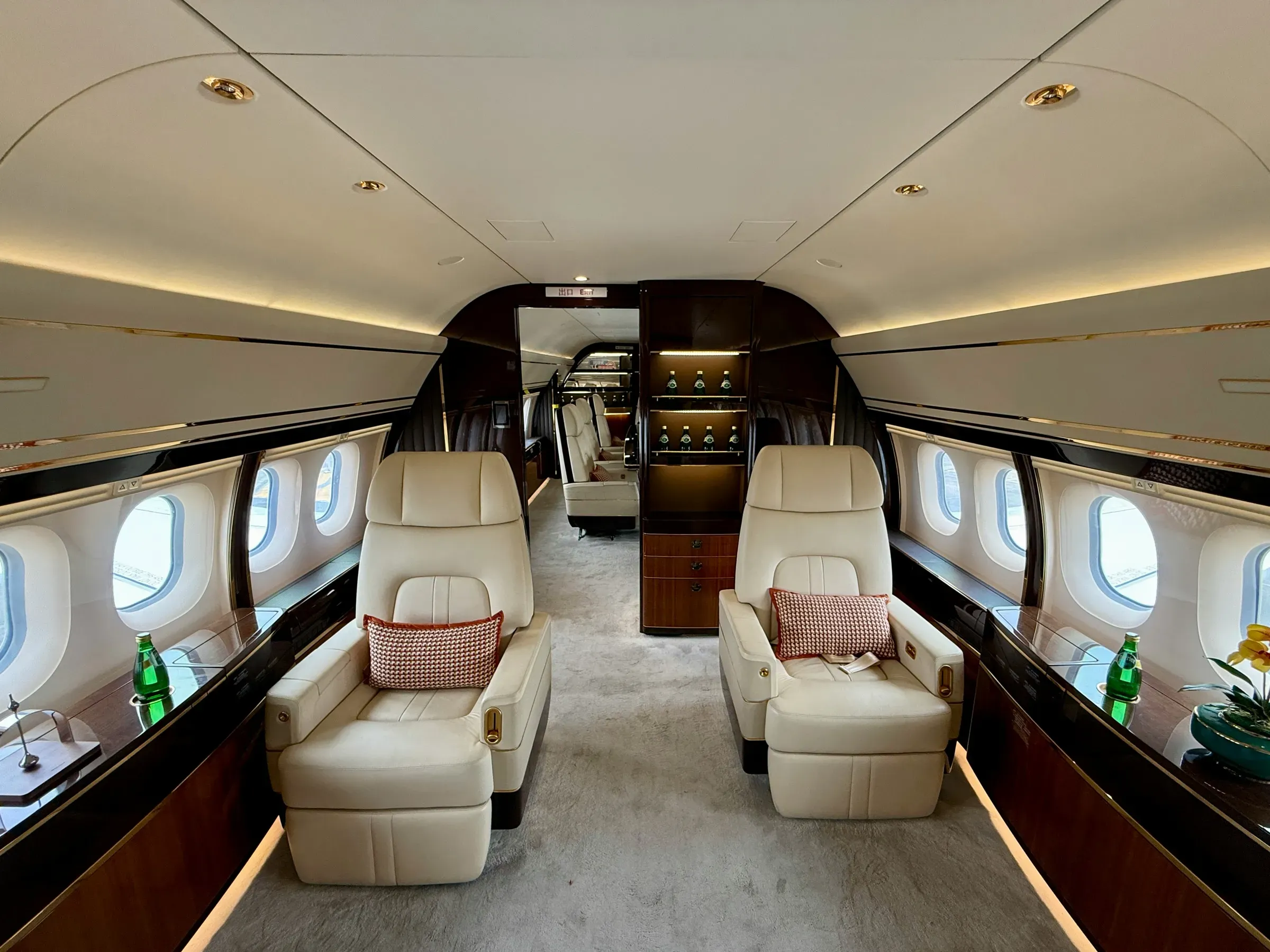 The cabin of a private jet with cream leather armchairs