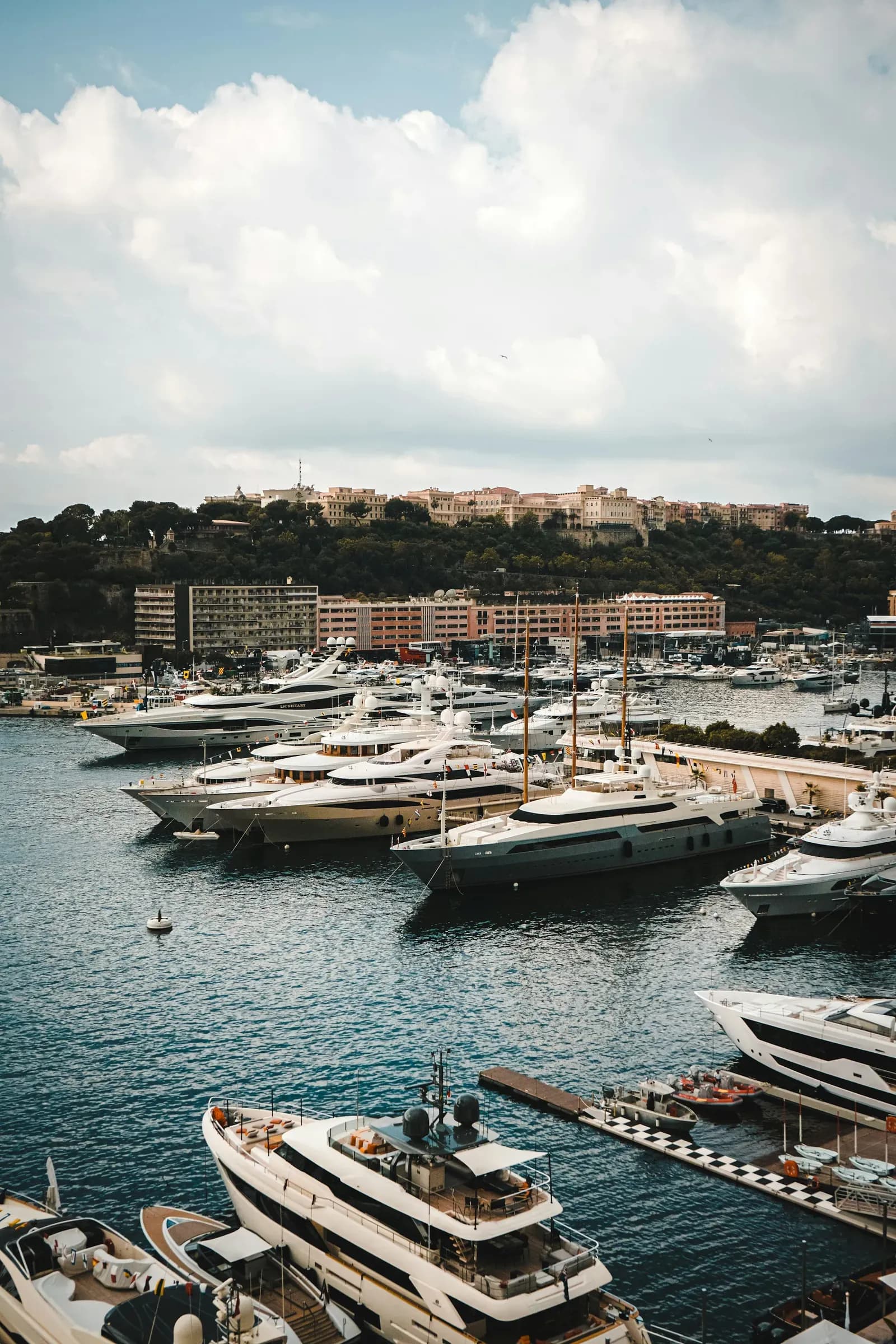 Yachts moored in a harbour below a hillside town
